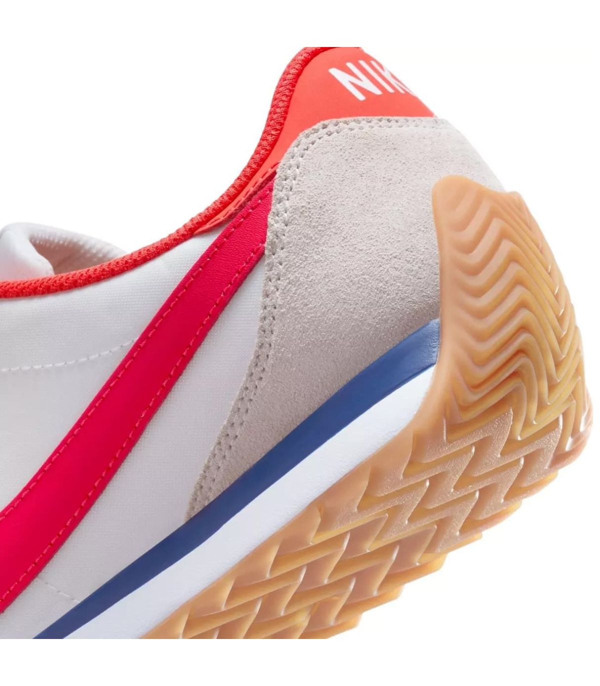 Nike Pacific blanca de tela y ante con logo rojo, detalle azul y suela de goma marrón con dibujo de espiga.